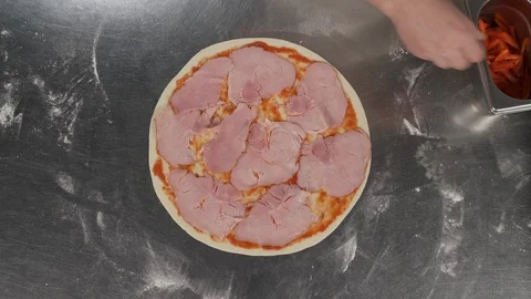 Restaurant kitchen. Top view of the chef putting sliced red pepper on the pizza. Stock Footage 121411133
