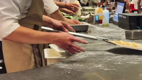 A restaurant kitchen worker carries the pizza on a peel. Stock Footage 319826188