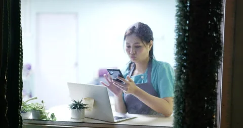 Restaurant manager surfing the web and conversing on her smartphone Stock Footage 172281093