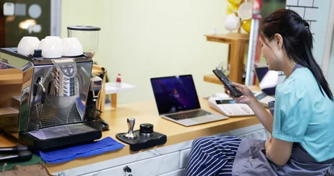 Restaurant manager surfing the web and conversing on her smartphone Stock Footage 172300846