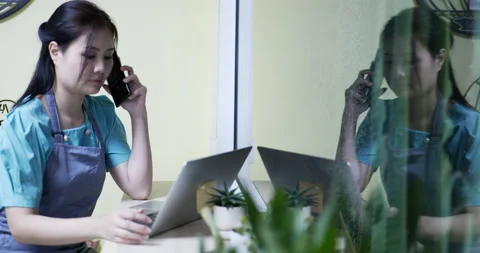 Restaurant manager surfing the web and conversing on her smartphone Stock Footage 172308340