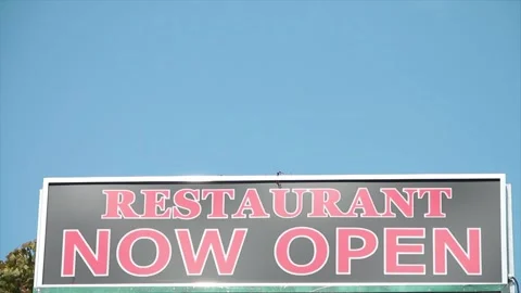 Restaurant now open writing caption text sign with blue sky and tree behind Stock Footage 249101040