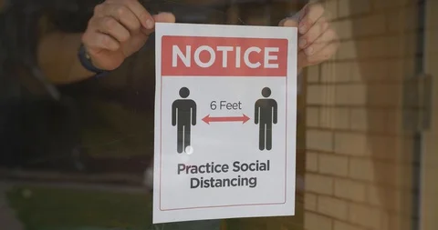 Restaurant Owner Puts Social Distance Sign on Door Stock Footage