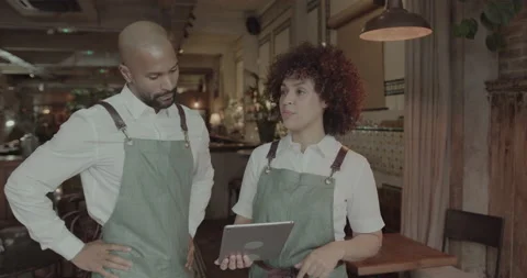 Restaurant Owners looking at new menu together on Digital tablet Stock Footage 221950513