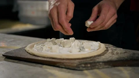 In the restaurant, a professional chef prepares pizza, adds sauce to the doug Stock Footage 221272476