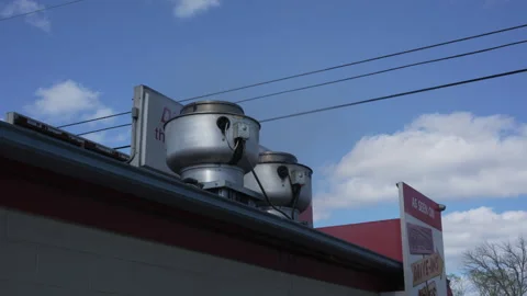 Restaurant rooftop ventilation fans under blue sky at roadside diner Stock Footage 334443343
