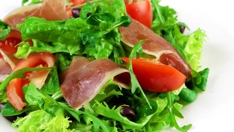 Restaurant salad with Hamon, lettuce leaf, arugula, tomatoes and olives Stock Footage 73508031