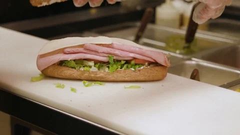 Restaurant sandwich shop worker making sandwich putting bread on top and 스톡 동영상 102296653