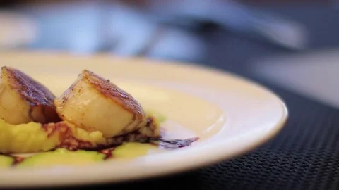 RESTAURANT SCALLOPS AND MASHED POTATOES BEING SERVED SLIDING ONTO TABLE Stock Footage 80695727