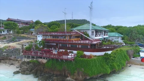A restaurant in the shape of a pinisi ship that feels on top of a cliff Stock Footage 168930545