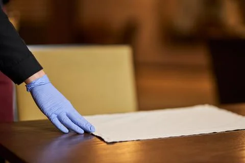 Restaurant staff using gloves for setting up tables Stock Photos