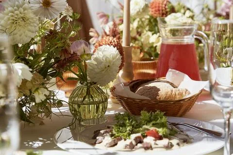 Restaurant summer aesthetics table setting, flowers arrangement under sunlight Stock Photos
