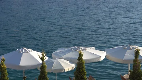 Restaurant with table, chairs and white umbrellas on a wooden jetty in the Stock Footage 97358526