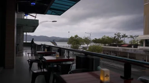 Restaurant table outside with bad weather raining dark sky Stock Footage 136564343