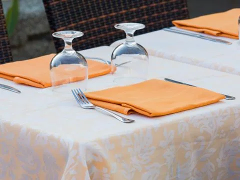 Restaurant table prepared with damask  table cloth orange napkin Stock Photos