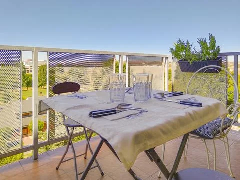 Restaurant table set for dinner on a sunny balcony Stock Photos