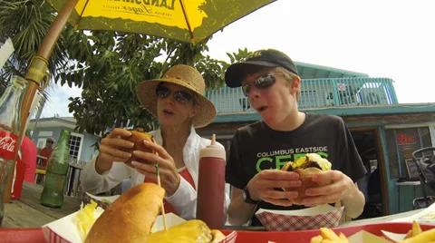 RESTAURANT, TROPICAL, MOM AND SON EAT BURGERS OUTSIDE Video stock 37154392