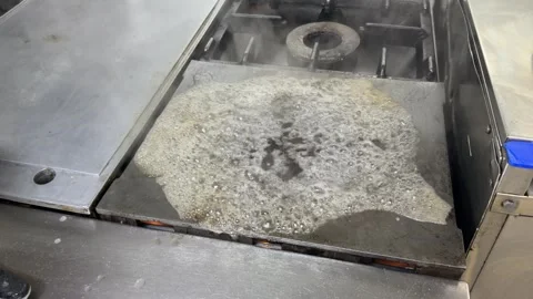 Restaurant worker cleaning a commercial kitchen griddle 動画素材 344100063