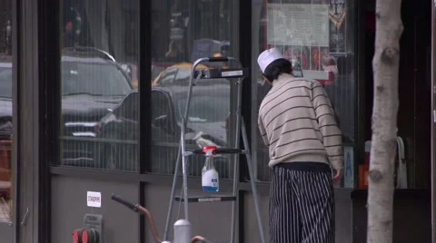 A restaurant worker cleaning windows in Manhattan Stock Footage 51301233