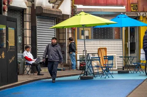 Restaurant workers take a break empty tables outside in Chinatown NYC Stock Photos