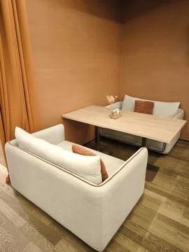 The restaurants cozy interior features soft sofas and a wooden table. Stock Photos