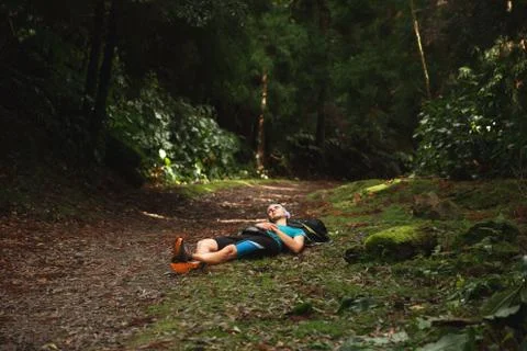 Restful young man lying down on ground in forest. Sao Miguel island, Azores Stock Photos