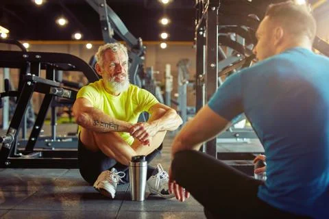 Resting after training. Athletic middle aged man discussing something with Foto stock