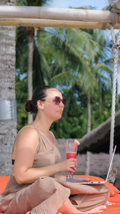 Resting on beach swing while working on laptop Stock Footage 315294292