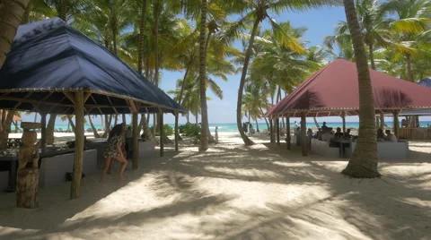 Resting on the beach under the large umbrellas in The Dominican Republic Stock Footage 50417081