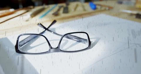 Resting black rectangular eyeglasses open on white paper at workspace, with Stock Photos