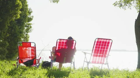 Resting on deckchairs in front of the lake Vidéo 170786715