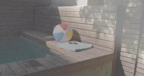 Resting multicolored beach ball on folded mint towel at backyard pool, with Stock Photos