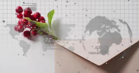 Resting red berry sprig lying on pale envelope at studio table, with map Stock Photos