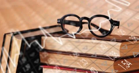 Resting stack of three hardcover books with round black eyeglasses on warm desk, Stock-Fotos