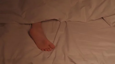 Restless feet of a kid boy on a sheet under a blanket at night. Baby child girl Vidéo 281767114