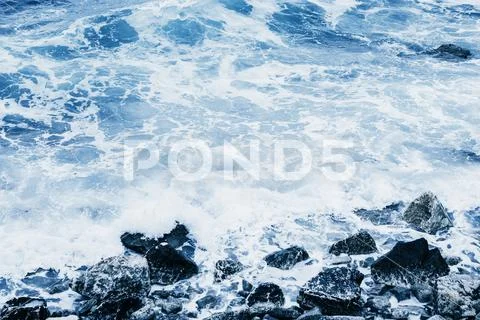 Restless sea near the stone coast. Stock Photos