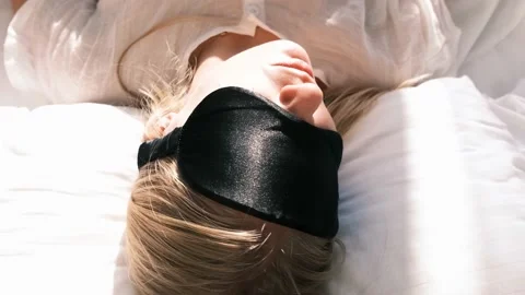 Restless sleep. View from above of a sleeping young blonde woman wearing a 動画素材 228962722