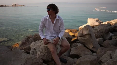 Restless young man struggles to relax and enjoy quiet time by the sea Stock Footage 341622760