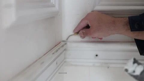 Restoration work ceiling cornice, spatula, white putty, white, male builder Stock Footage 303406603