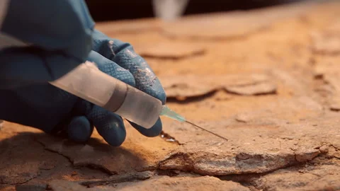 The restorer introduces the adhesive solution with a syringe into the cracks  Stock Footage 119488202