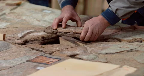 A restorer in a workshop carefully selects pieces of a historical monument  Stock Footage 119547645