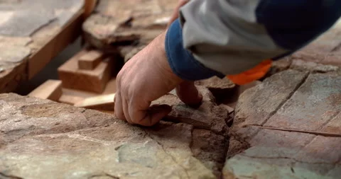 A restorer in a workshop carefully selects pieces of a historical monument  Stock Footage 119547899