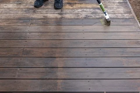 Restoring Weathered Deck Boards with Long Handled Scrub Brush Stock Photos