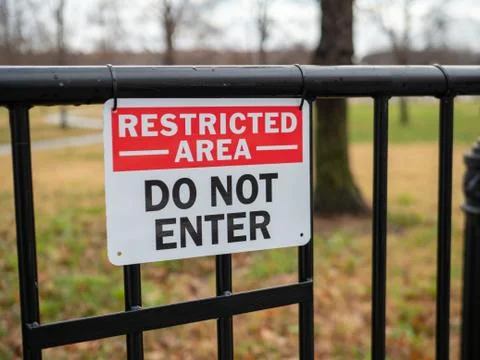 Restricted area do not enter sign hung on black gate Foto stock