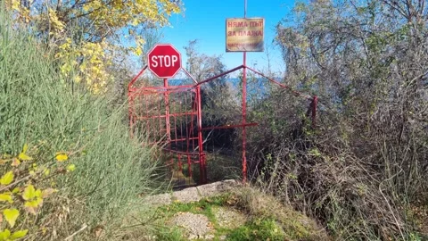 Restricted coastal path with red gate and stop sign in motion Stock Footage 322161069