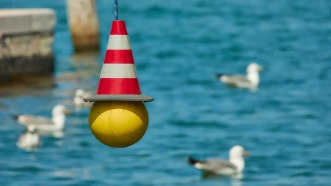 Restrictive striped red and white beacon hanging on the background of floatin Stock Footage 110857969