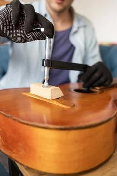 Restring classical guitar concept. The man repair an old guitar. Stock Photos