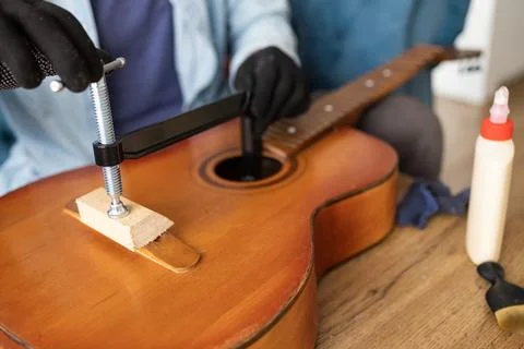 Restring classical guitar concept. The man repair an old guitar. Stock Photos