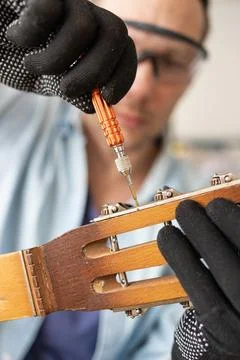 Restring classical guitar concept. The man repair an old guitar. Stock Photos