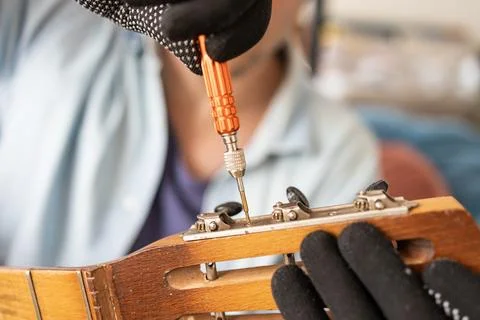 Restring classical guitar concept. The man repair an old guitar. Stock Photos